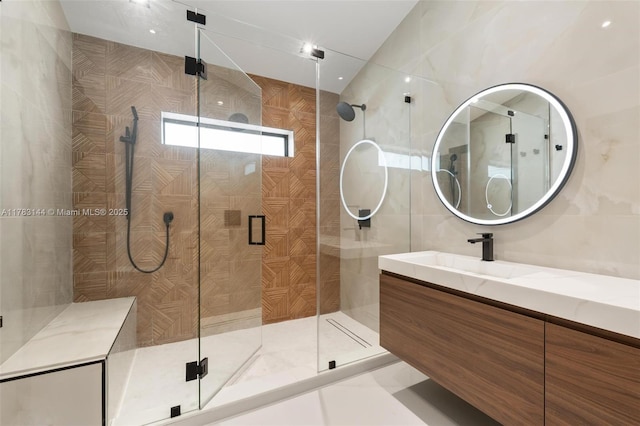bathroom with a stall shower, vanity, and tile walls