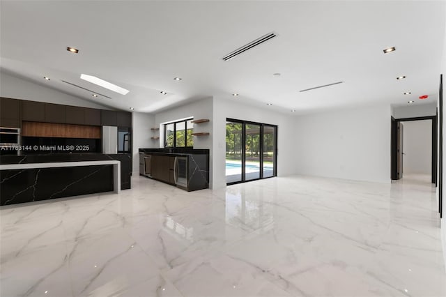 interior space featuring marble finish floor, lofted ceiling with skylight, visible vents, and recessed lighting