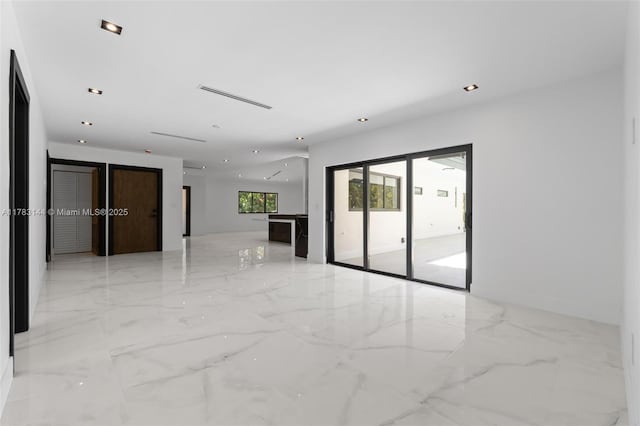 empty room featuring marble finish floor and recessed lighting