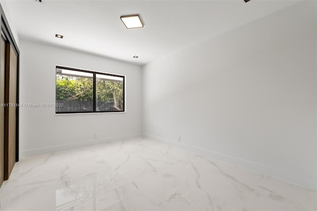 unfurnished bedroom with baseboards and marble finish floor