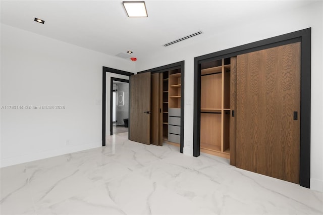 unfurnished bedroom with baseboards, marble finish floor, multiple closets, and visible vents