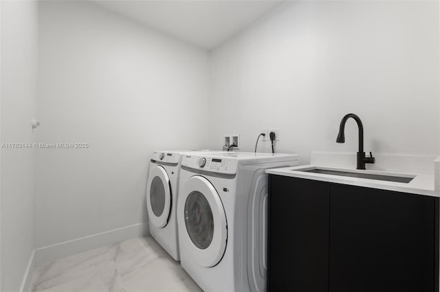 washroom featuring washer and clothes dryer, a sink, marble finish floor, laundry area, and baseboards
