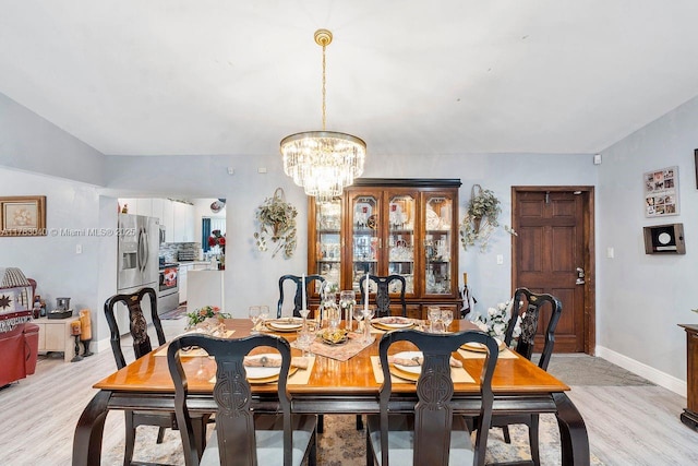 18201 SW 87th Ave, Palmetto Bay, FL 33157 - dining area featuring a chandelier, light wood-style flooring, and baseboards