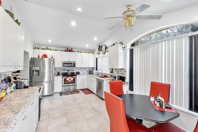 18201 SW 87th Ave, Palmetto Bay, FL 33157 - kitchen featuring appliances with stainless steel finishes, tasteful backsplash, light countertops, white cabinetry, and vaulted ceiling