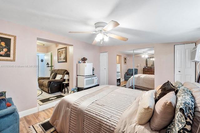 18201 SW 87th Ave, Palmetto Bay, FL 33157 - bedroom featuring multiple closets, light wood-type flooring, baseboards, a ceiling fan, and an AC wall unit
