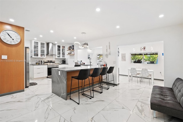 5117 Washington St, Hollywood, FL 33021 - kitchen featuring a kitchen bar, recessed lighting, wall chimney range hood, and stainless steel appliances