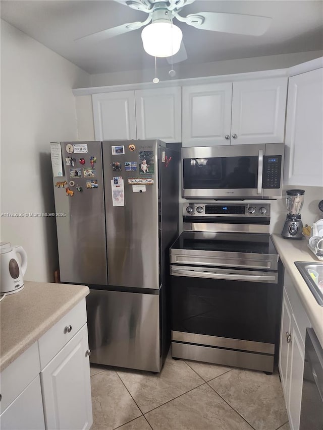 2114 E Cambridge E Unit 2114, Deerfield Beach, FL 33442 - kitchen featuring light tile patterned floors, white cabinets, and stainless steel appliances