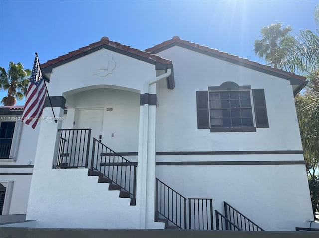 view of front of property with stairway and stucco siding