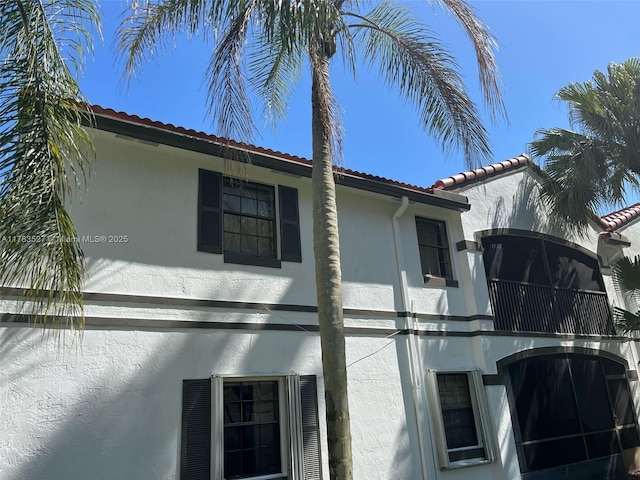 view of property exterior with a tiled roof and stucco siding