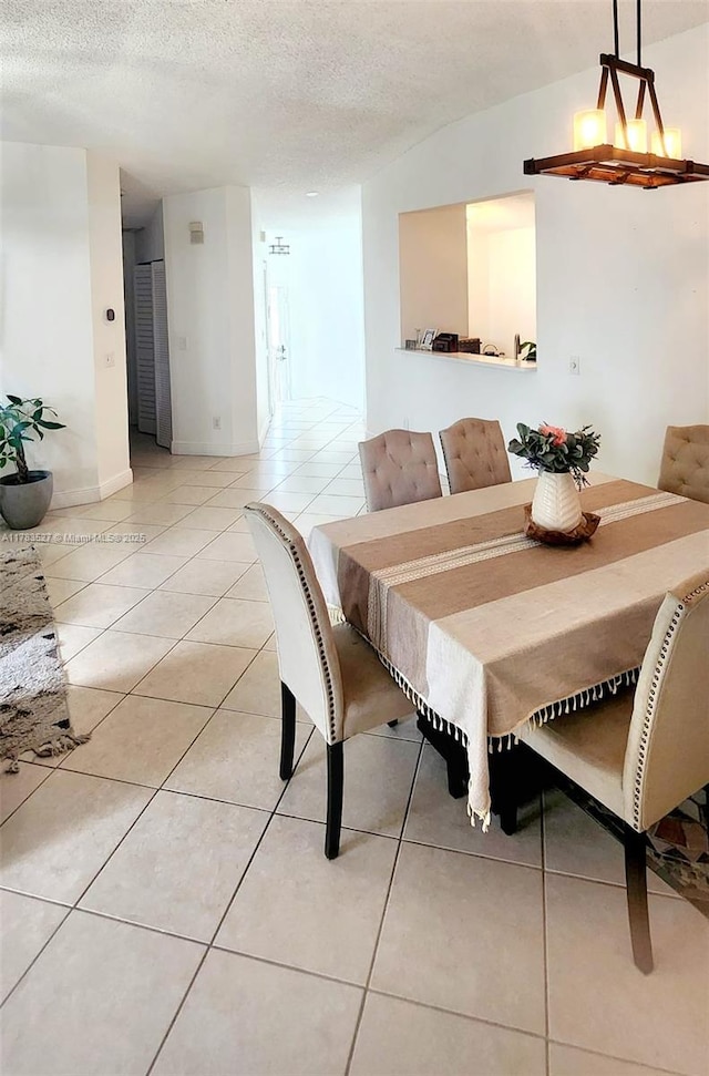 dining space with a textured ceiling and light tile patterned floors