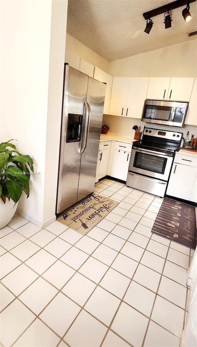 kitchen featuring stainless steel appliances, light countertops, visible vents, a textured ceiling, and white cabinetry