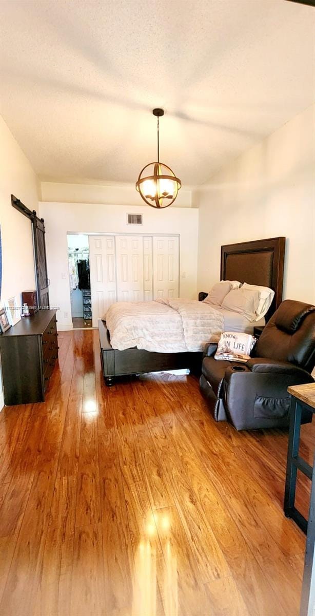 502 SW 158th Ter Unit 203, Pembroke Pines, FL 33027 - bedroom with hardwood / wood-style flooring, a chandelier, and a barn door
