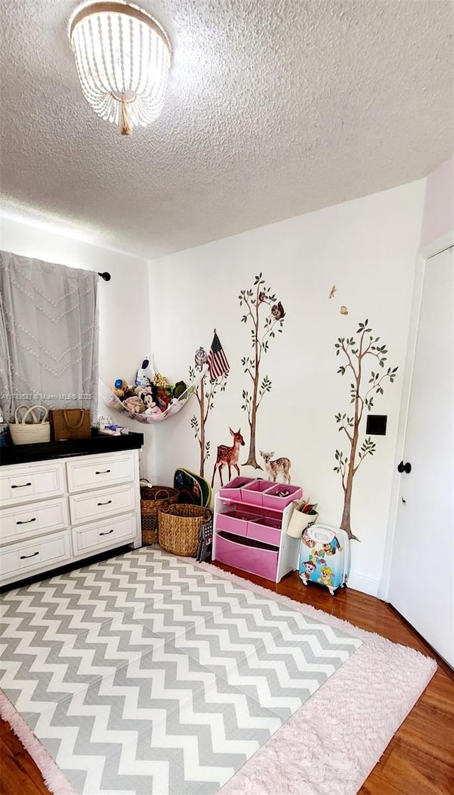 bedroom with light wood-type flooring and a textured ceiling