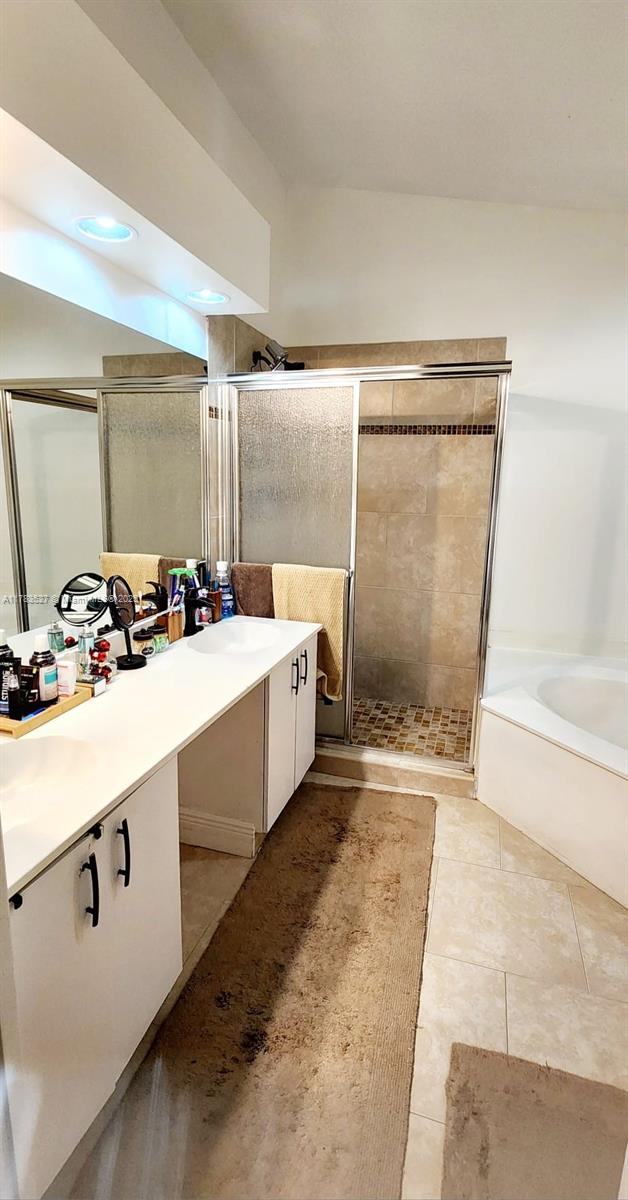 502 SW 158th Ter Unit 203, Pembroke Pines, FL 33027 - full bath with vanity, a stall shower, a garden tub, and tile patterned floors