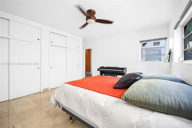 bedroom with marble finish floor, two closets, and a ceiling fan