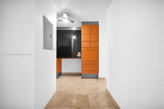 hall featuring baseboards and electric panel