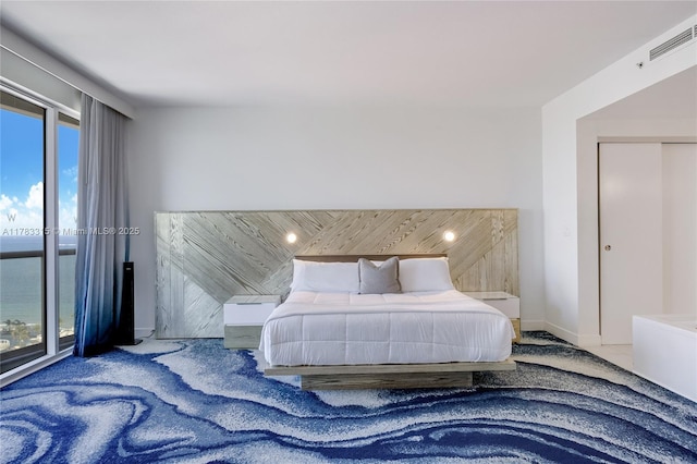 bedroom featuring access to exterior, visible vents, multiple windows, and baseboards