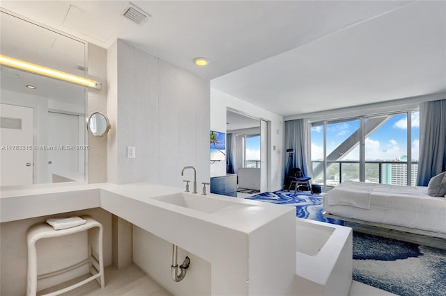 bedroom with a sink, visible vents, and access to exterior
