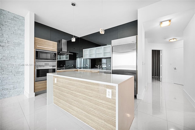 kitchen featuring built in appliances, wall chimney exhaust hood, modern cabinets, and light tile patterned flooring