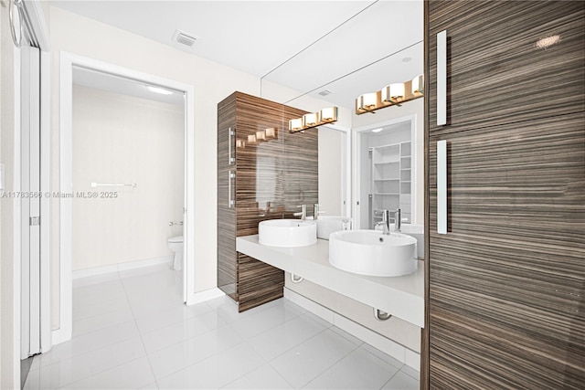 bathroom featuring a sink, tile patterned floors, toilet, and baseboards