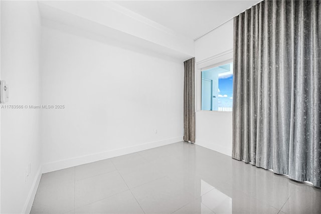 tiled spare room featuring baseboards