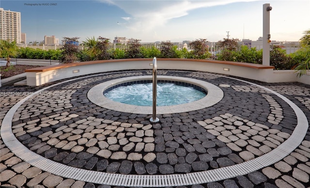 view of pool featuring fence and a hot tub