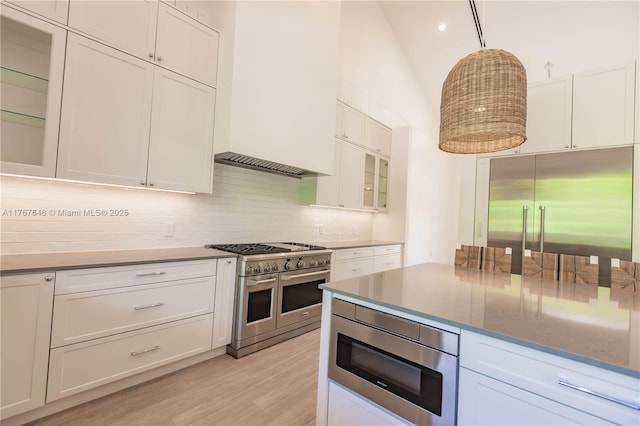 8200 SW 62nd Ave, Miami, FL 33143 - kitchen with white cabinets, light wood-style floors, built in appliances, backsplash, and glass insert cabinets
