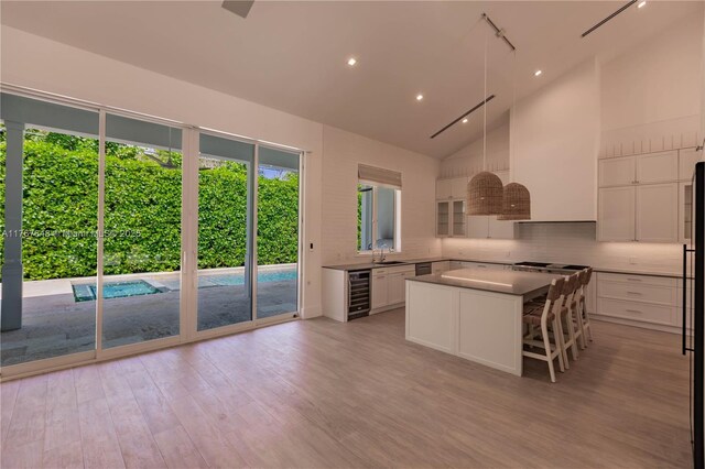 8200 SW 62nd Ave, Miami, FL 33143 - kitchen with a center island, tasteful backsplash, beverage cooler, light wood-style floors, and white cabinetry