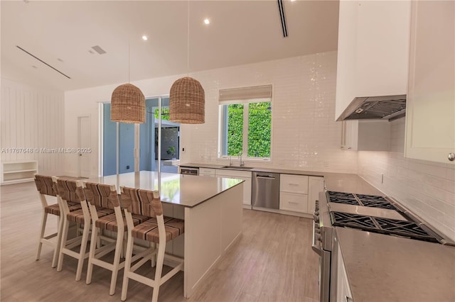 8200 SW 62nd Ave, Miami, FL 33143 - kitchen with light wood-style flooring, appliances with stainless steel finishes, backsplash, and white cabinets