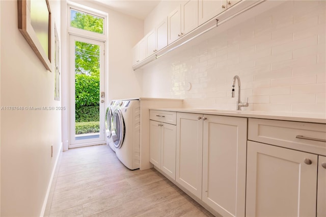 8200 SW 62nd Ave, Miami, FL 33143 - washroom with baseboards, light wood-style flooring, washing machine and clothes dryer, a sink, and cabinet space