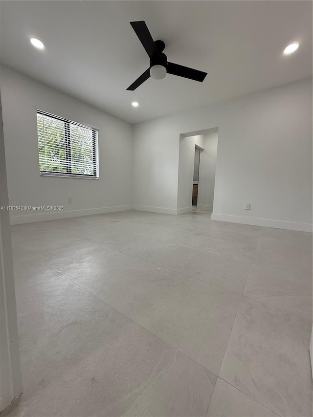 spare room featuring concrete flooring, ceiling fan, recessed lighting, and baseboards