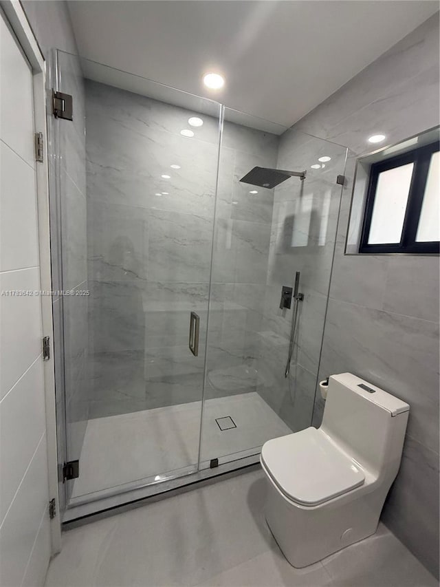 bathroom with a shower stall, recessed lighting, tile walls, and toilet