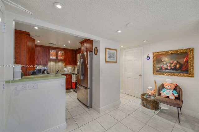 1950 S Ocean Dr Unit 17E, Hallandale Beach, FL 33009 - kitchen with stainless steel fridge with ice dispenser, baseboards, light tile patterned floors, light countertops, and a sink