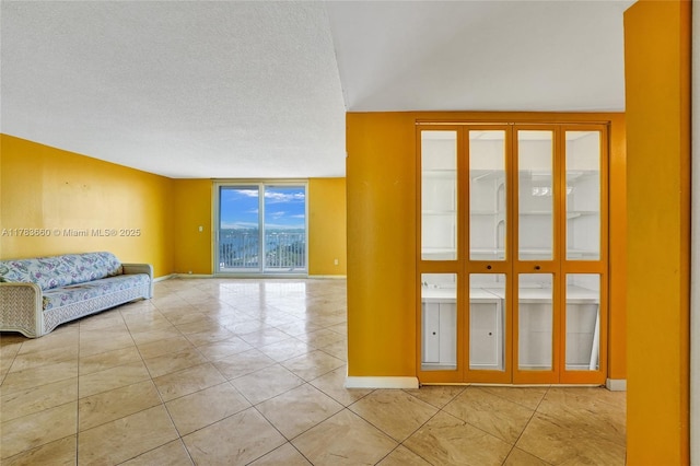 1401 S Ocean Dr Unit 902, Hollywood, FL 33019 - unfurnished room featuring light tile patterned flooring, expansive windows, a textured ceiling, and baseboards