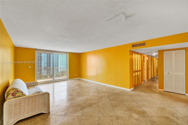 1401 S Ocean Dr Unit 902, Hollywood, FL 33019 - living area with a textured ceiling, baseboards, light tile patterned flooring, and a wall of windows