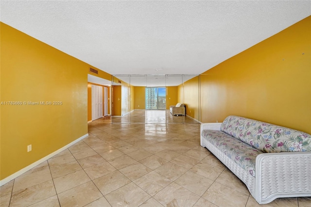 1401 S Ocean Dr Unit 902, Hollywood, FL 33019 - living area featuring light tile patterned floors, baseboards, and a textured ceiling