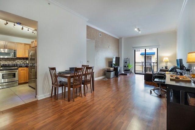 dining area featuring light wood-type flooring, baseboards, and ornamental molding