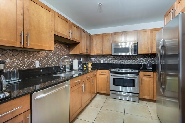 8390 SW 72nd Ave Unit 517, Miami, FL 33143 - kitchen featuring appliances with stainless steel finishes, light tile patterned floors, backsplash, and brown cabinets