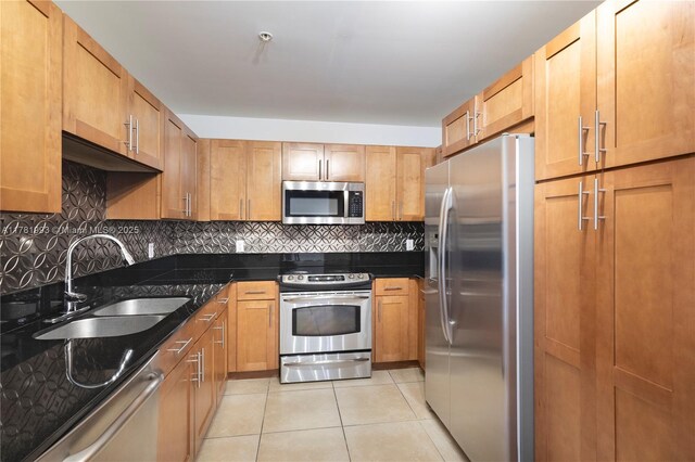 8390 SW 72nd Ave Unit 517, Miami, FL 33143 - kitchen featuring stainless steel appliances, light tile patterned flooring, tasteful backsplash, dark stone countertops, and brown cabinetry