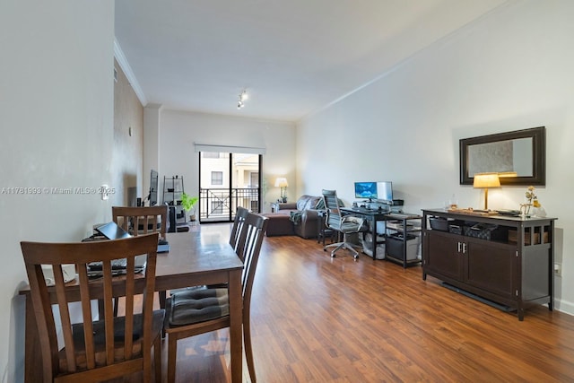 dining space with ornamental molding and wood finished floors
