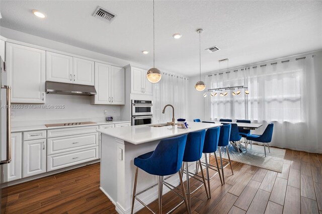 1705 Trailhead Ter, Hollywood, FL 33021 - kitchen featuring under cabinet range hood, black electric stovetop, visible vents, and a sink