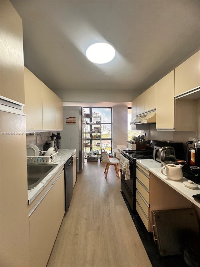 18181 NE 31st Ct Unit 1108, Aventura, FL 33160 - kitchen featuring a sink, light countertops, light wood-style flooring, under cabinet range hood, and black appliances