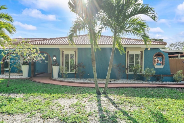 rear view of property with a tile roof and stucco siding