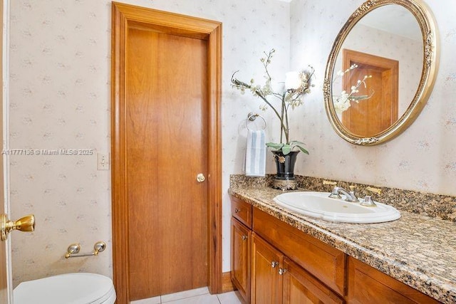 bathroom featuring wallpapered walls, toilet, and vanity