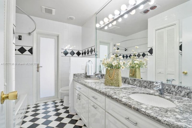 full bathroom featuring visible vents, toilet, a closet, and a sink