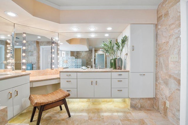 bathroom featuring ornamental molding, a sink, two vanities, and tiled shower