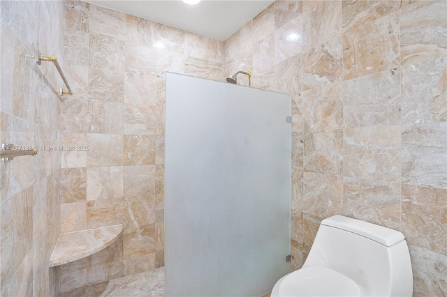 bathroom with tile walls, a walk in shower, and toilet