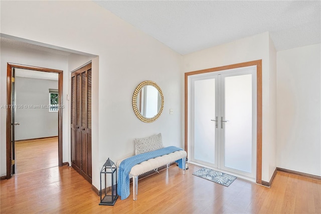 foyer with light wood-style flooring and baseboards