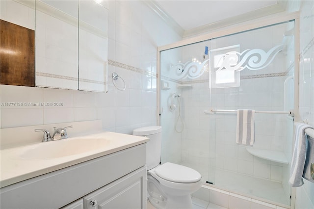 bathroom featuring a shower stall, tile walls, toilet, vanity, and crown molding