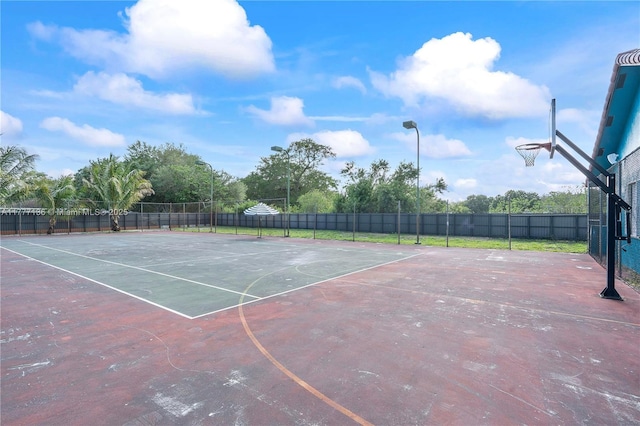 view of tennis court featuring fence and community basketball court